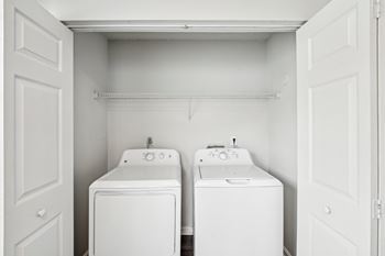 A small laundry room with a washer and dryer in it.